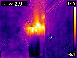 Termografía de la puerta de una cámara frigorífica: una lengua de calor entra por el marco, con mínima de -2.9 °C